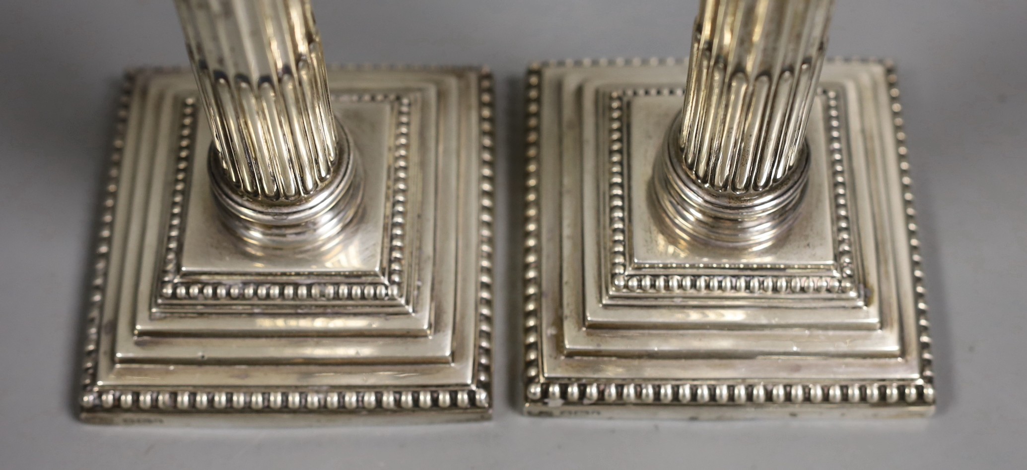A pair of Edwardian silver Corinthian column candlesticks, Hawksworth, Eyre & Co, Sheffield, 1903, height 25.5cm, weighted.